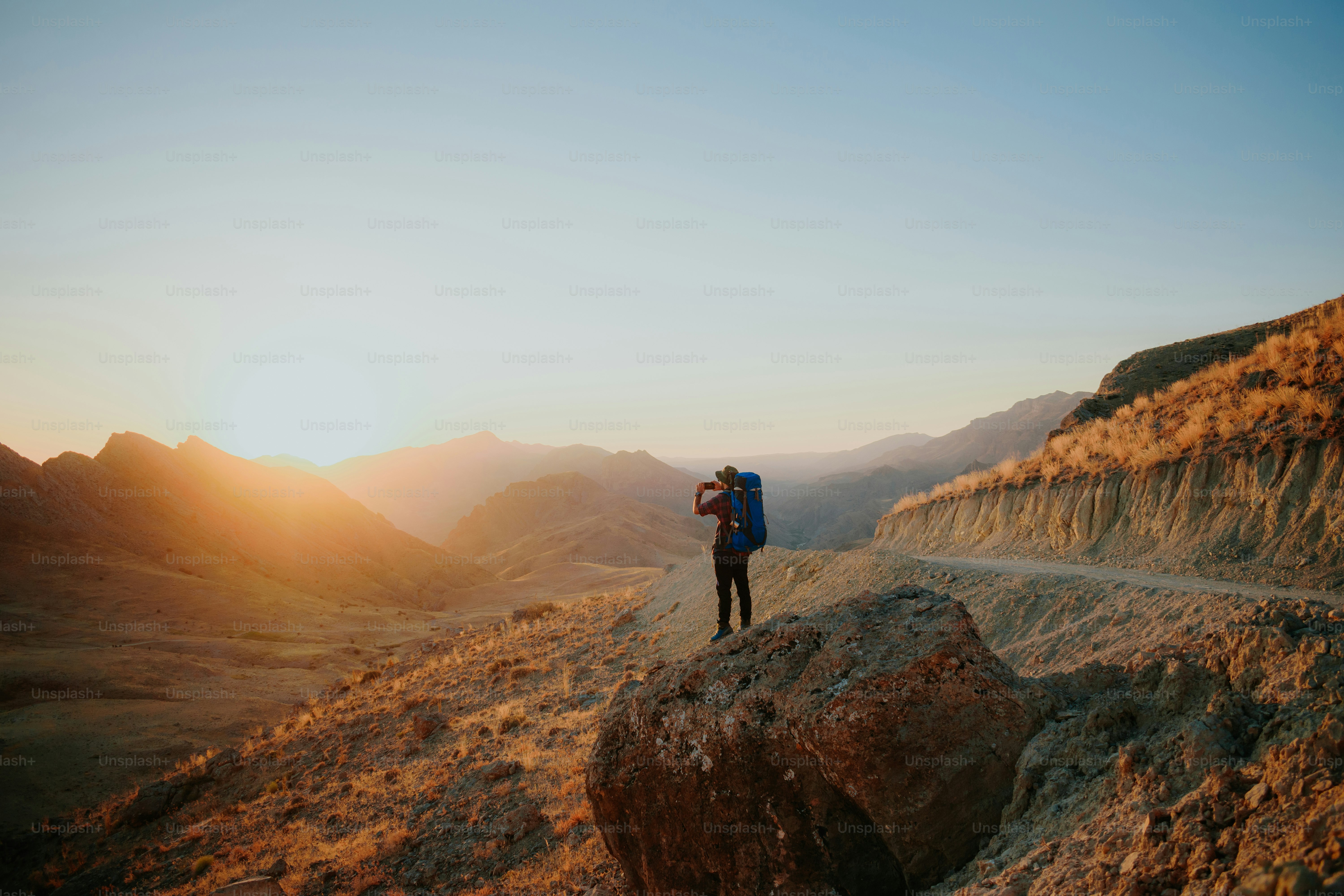 a person with a backpack standing on a hill