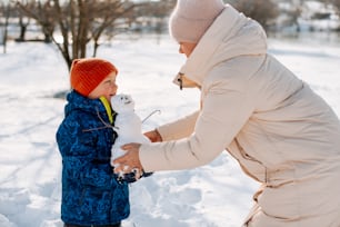 une femme tenant un petit enfant dans la neige