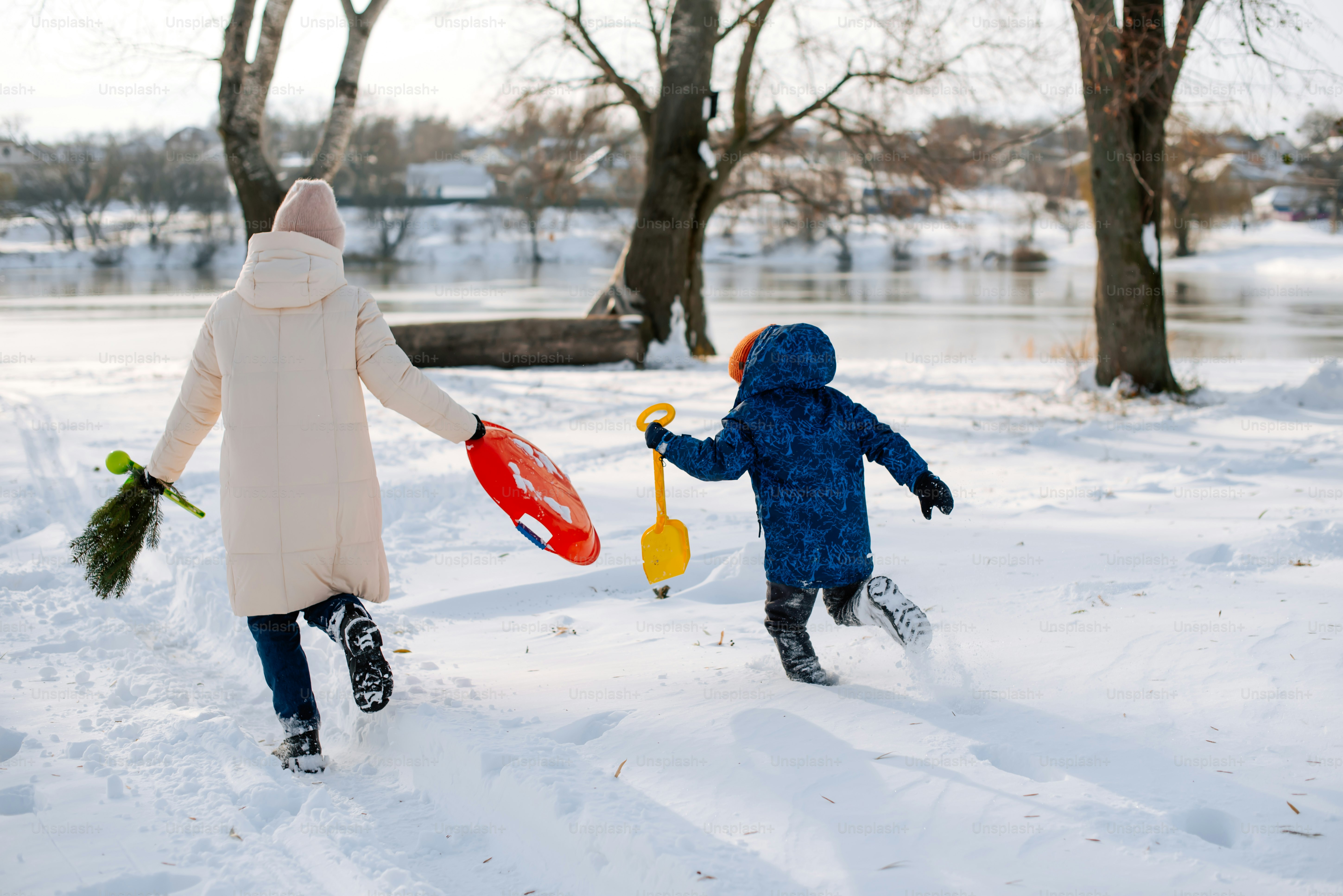 a woman and a child playing in the snow
