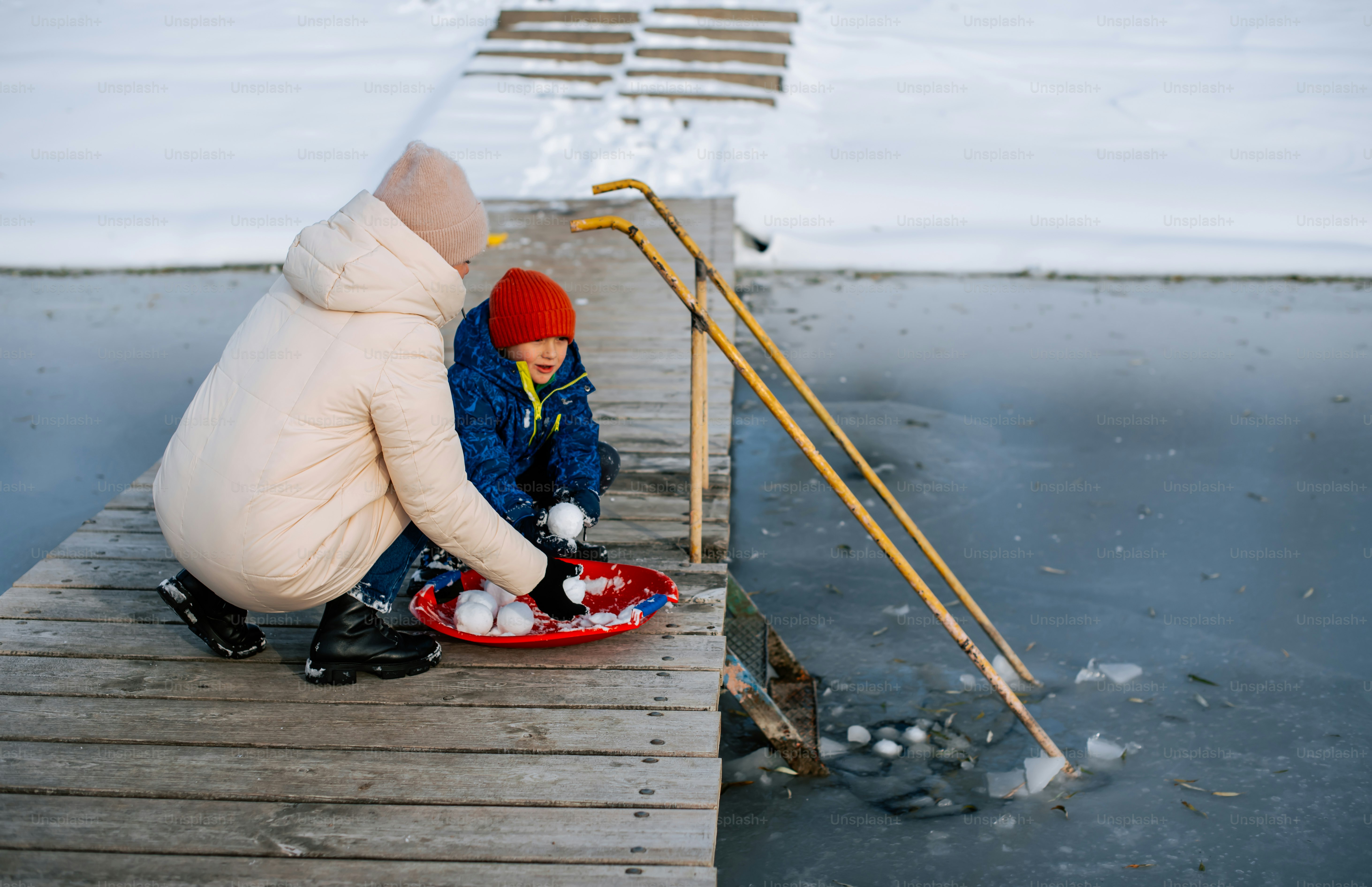 a person sitting on a dock with a snowboard
