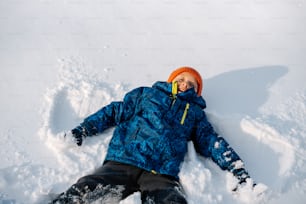 a person laying in the snow on a snowboard