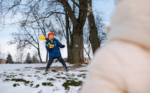 雪の中でフリスビーで遊ぶ少年