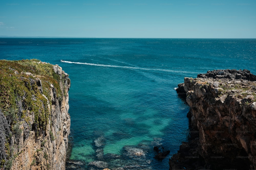 a boat is in the water near a cliff