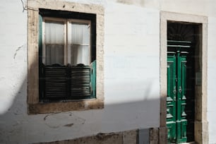 a building with two windows and a green door