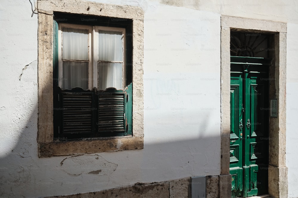 a building with two windows and a green door