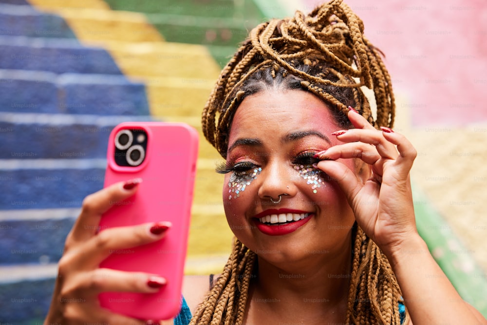 uma mulher segurando um celular rosa na frente de seu rosto
