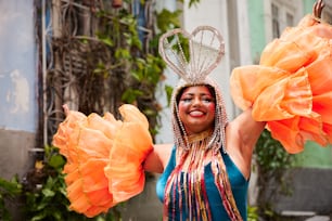 a woman in a costume holding two large orange flowers