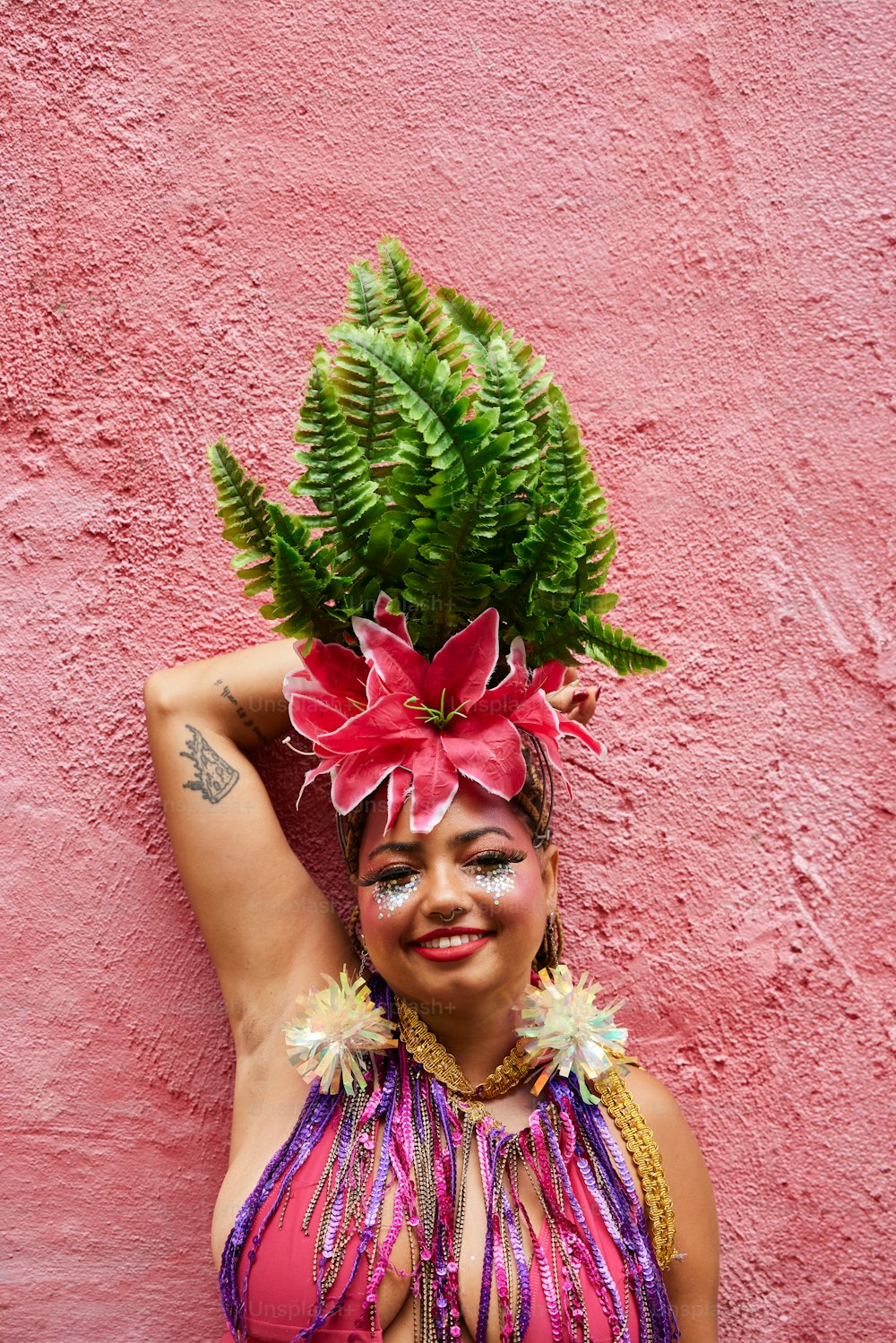 a woman in a pink bikini with a green plant on her head