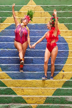 two women in bathing suits walking down a set of stairs