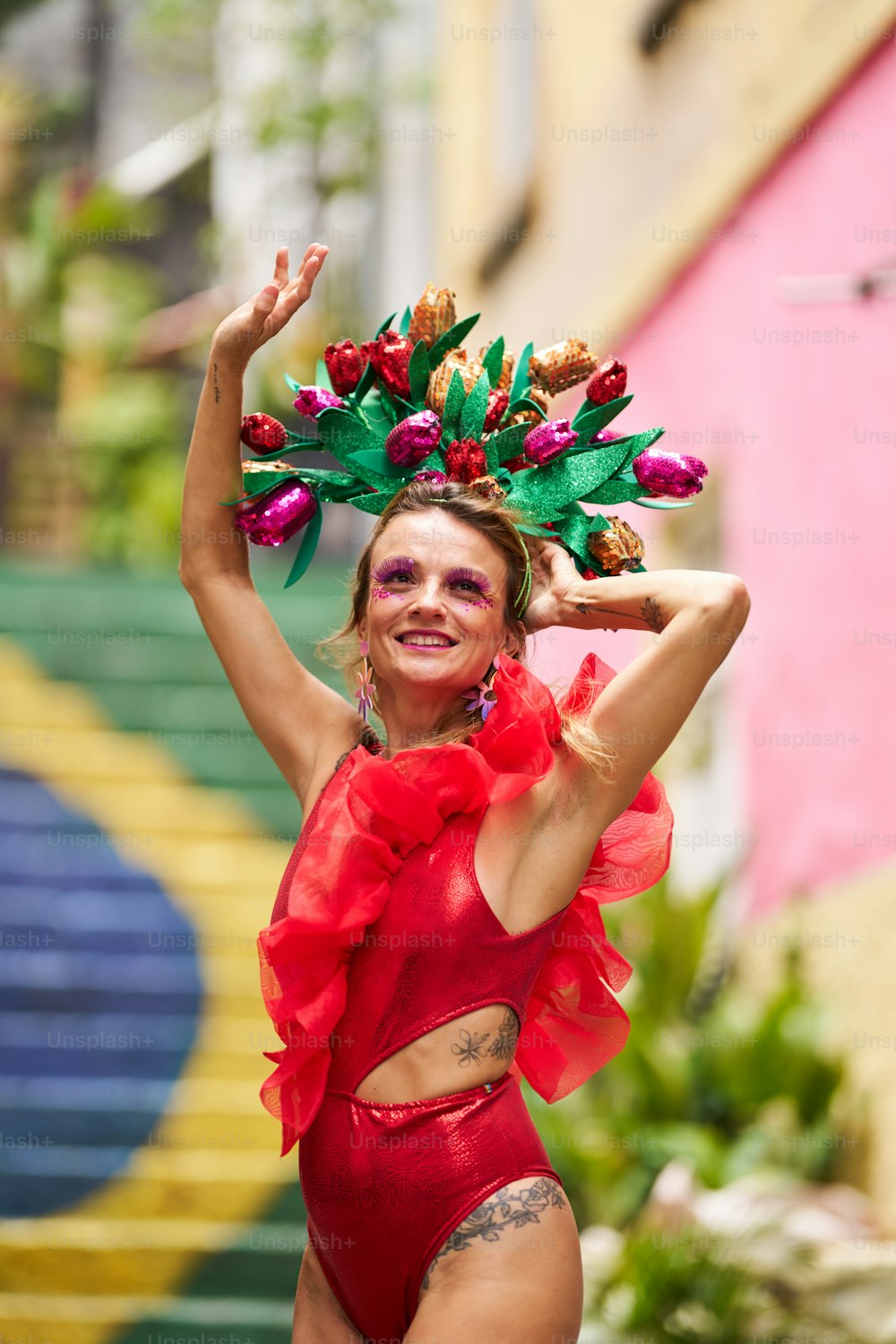 a woman in a red bodysuit with a flower crown on her head