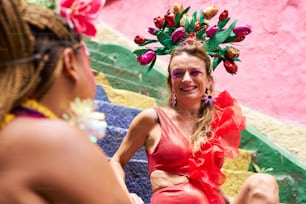 a woman wearing a red dress and a flower headpiece
