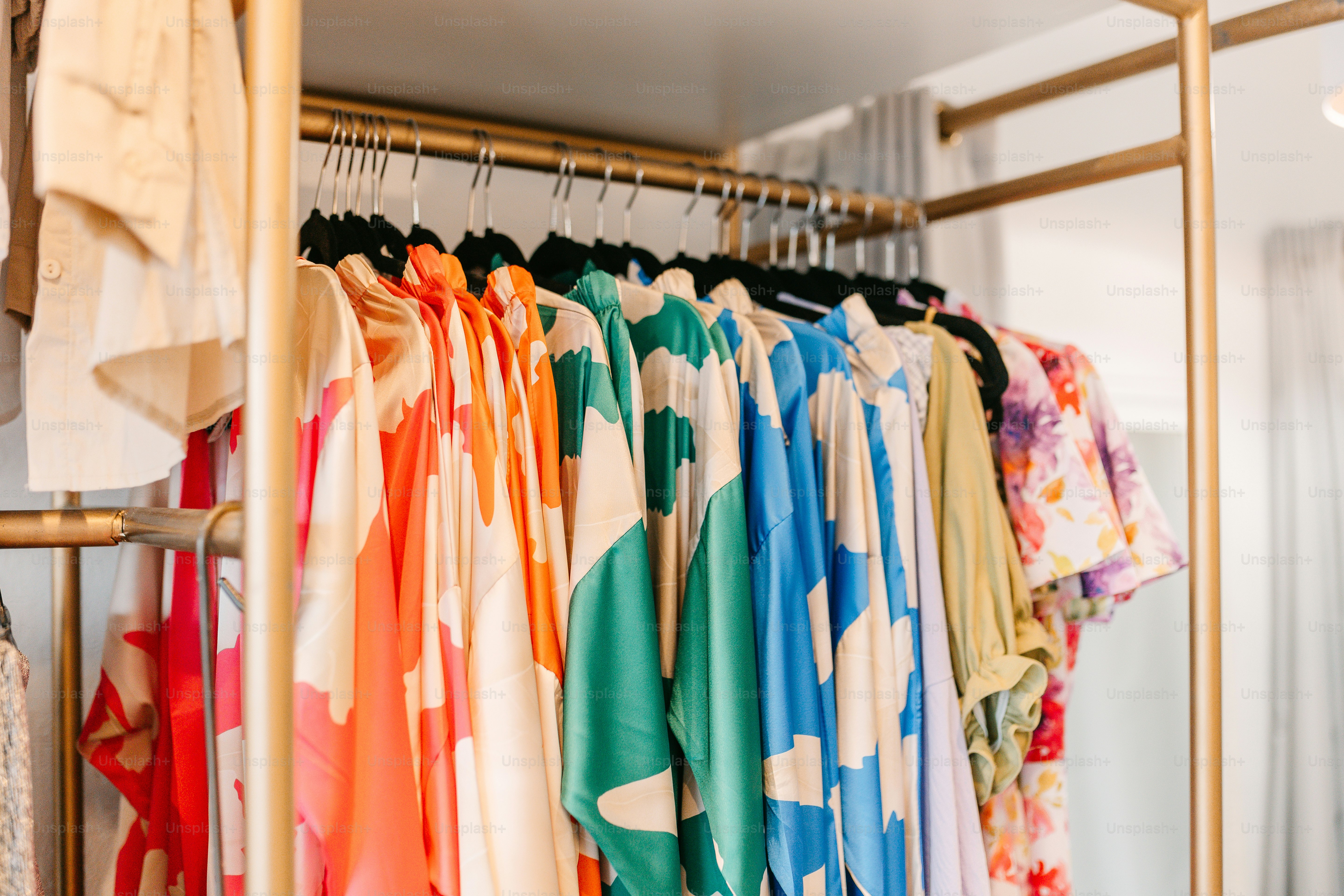 A rack of colorful shirts hanging on a rack photo – Shopping Image on ...