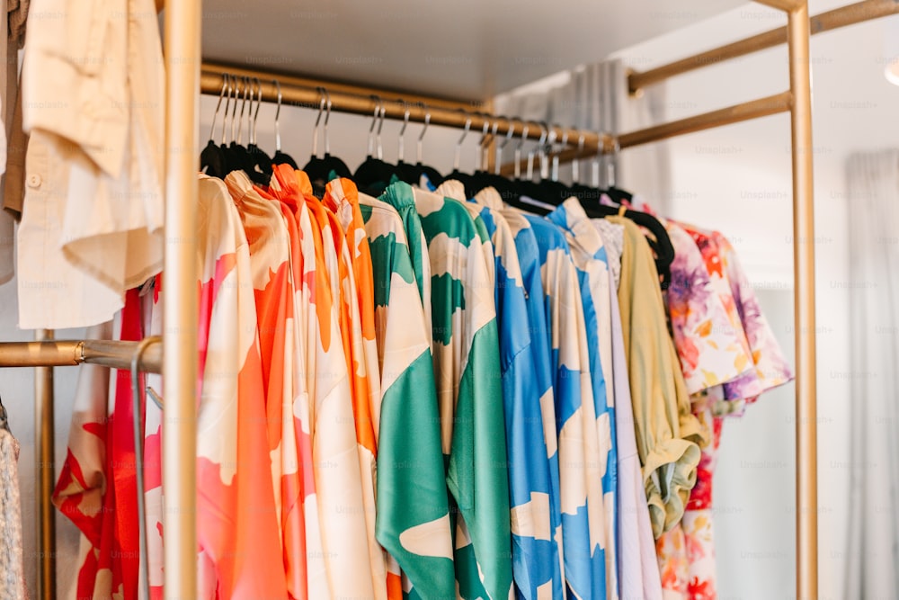 a rack of colorful shirts hanging on a rack