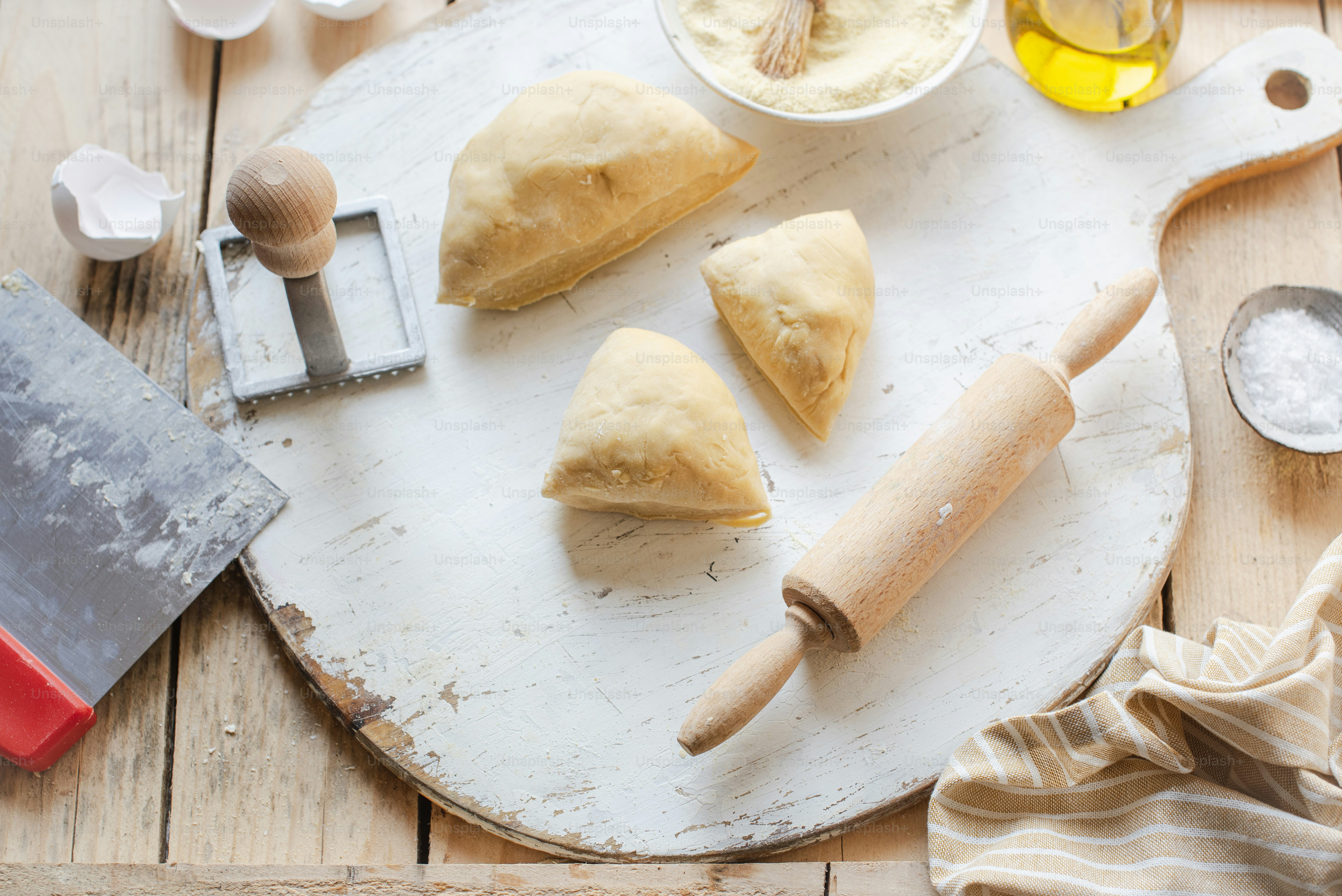 a wooden table topped with pastries and a rolling pin