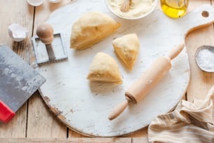 a wooden table topped with pastries and a rolling pin