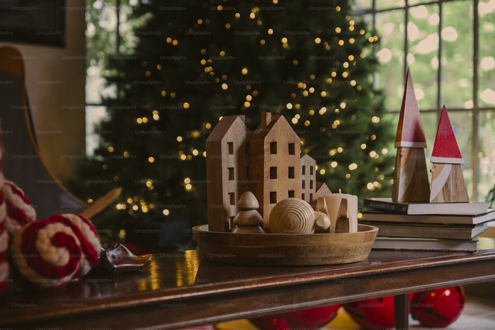 a christmas tree is in the background behind a wooden model of a house