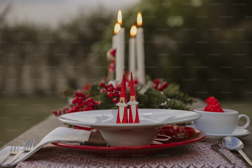 a red and white place setting with candles