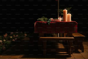 uma mesa com uma toalha de mesa vermelha e duas velas sobre ela