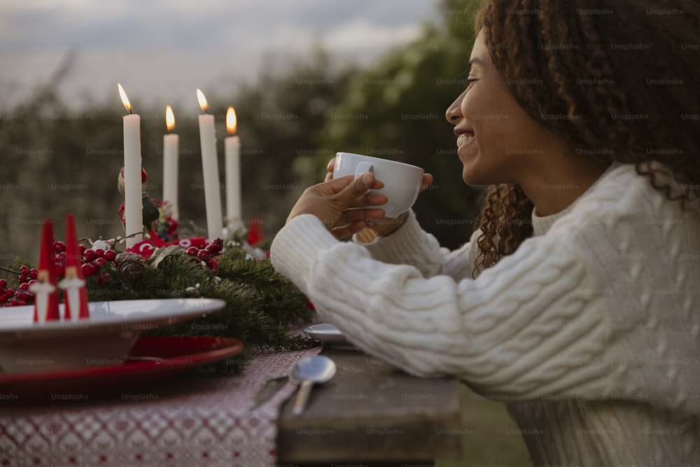 a woman sitting at a table with a cup of coffee