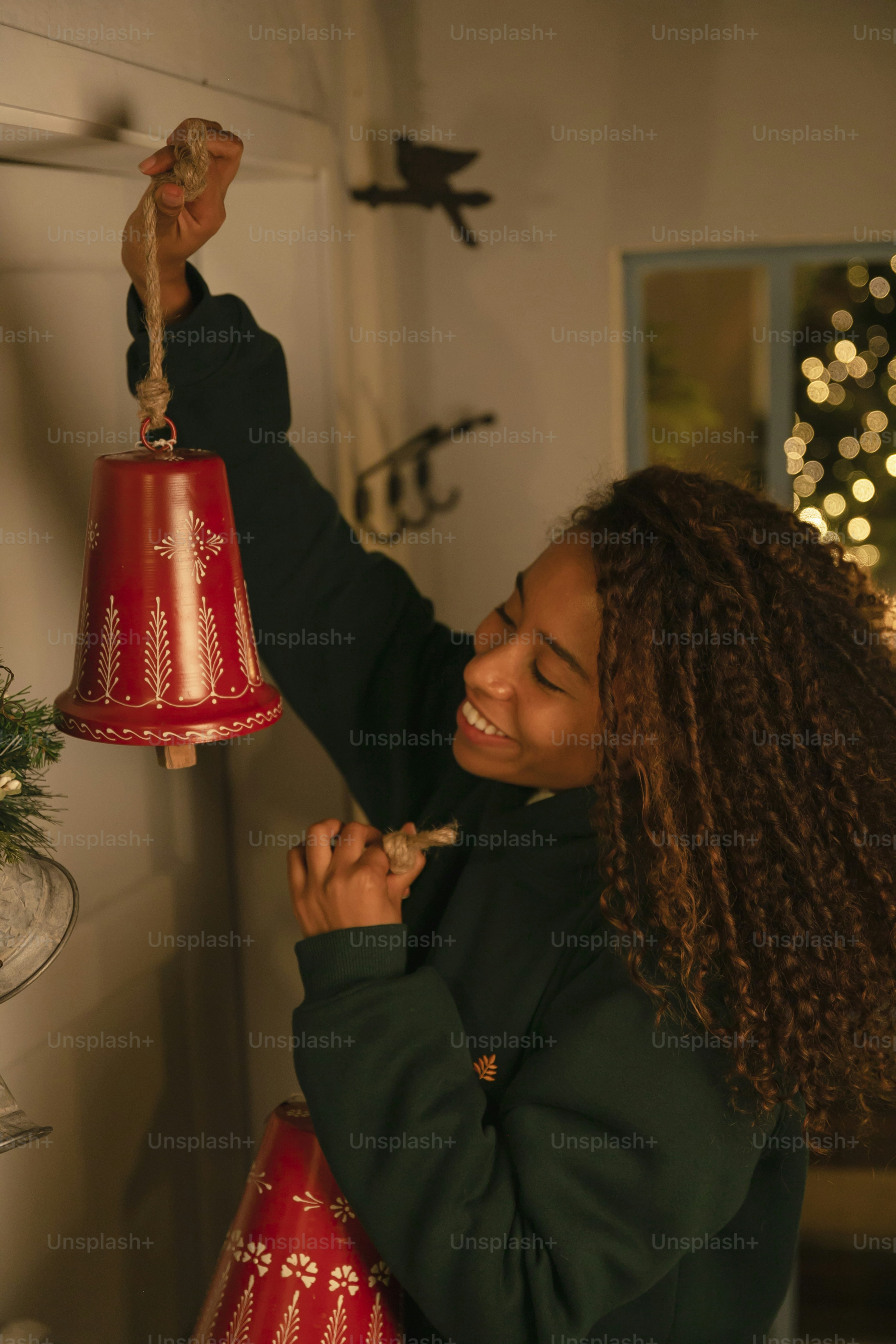 a woman holding a red bell with a bird on it