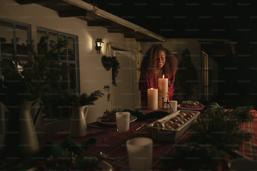 a woman sitting at a table with a lit candle