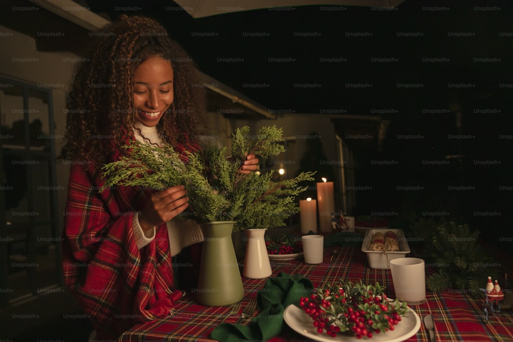 a woman arranging greenery on a table