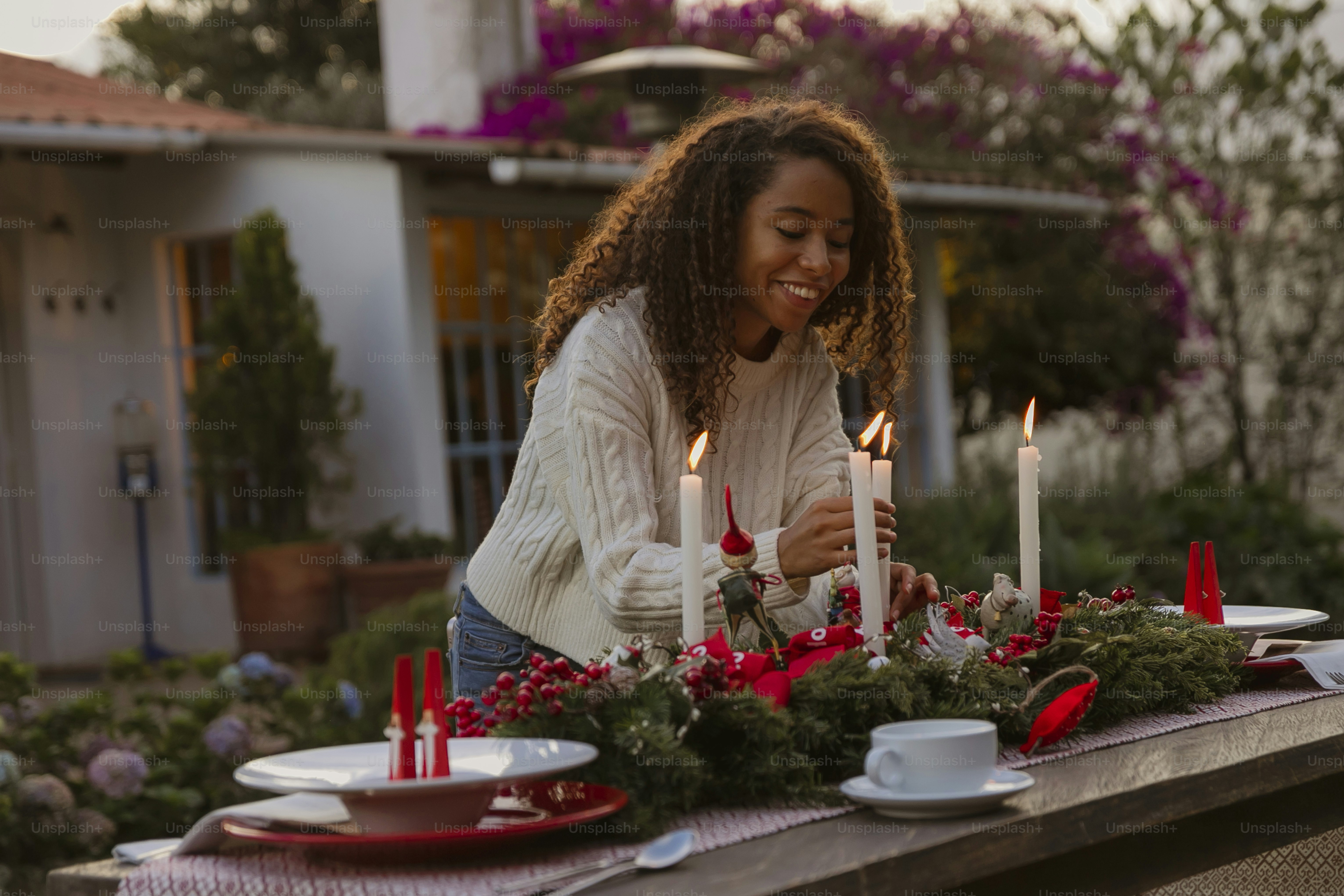 a woman sitting at a table with candles in front of her