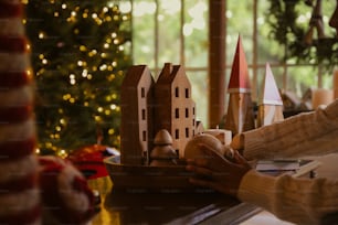 a person sitting at a table with a model of a house