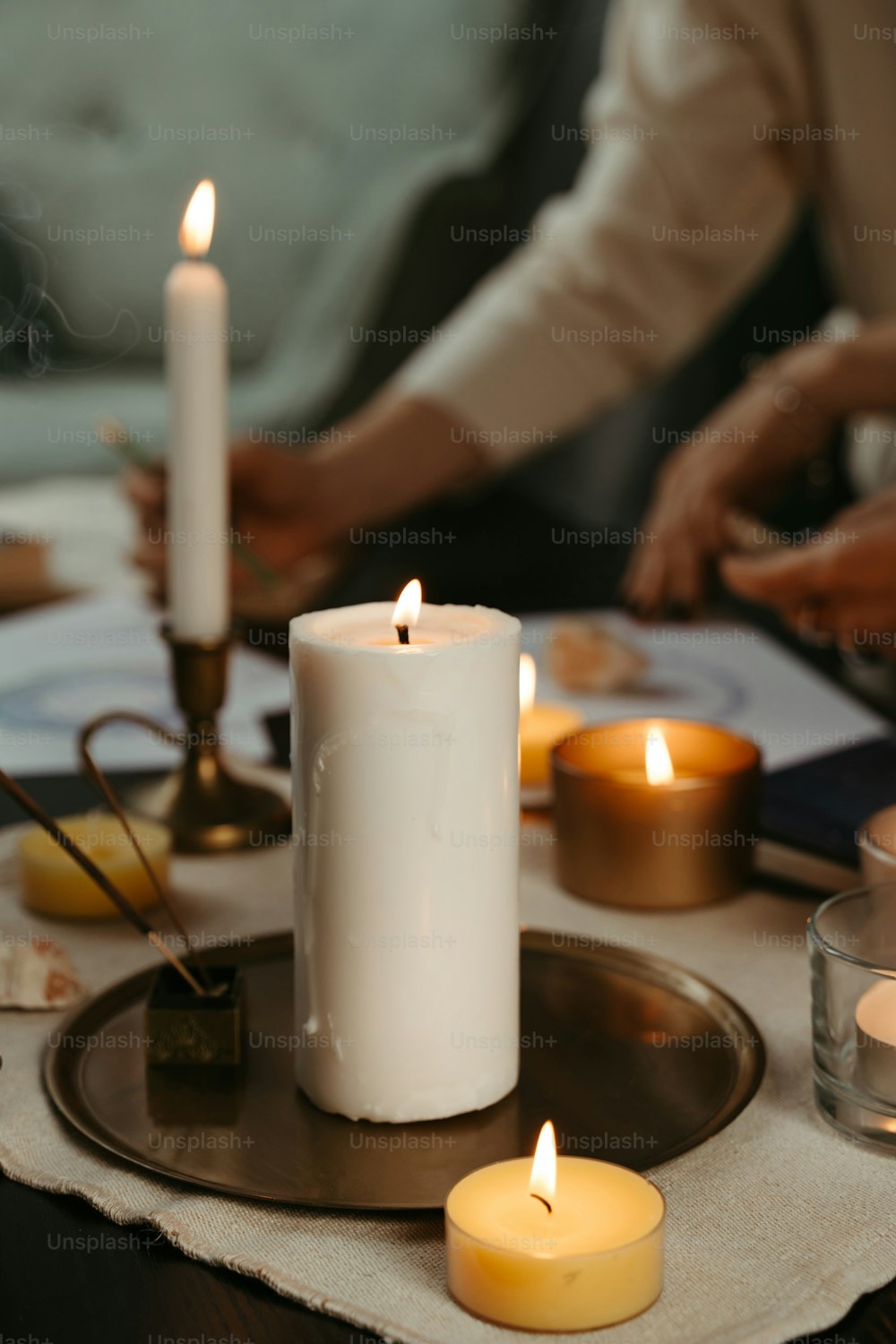 a group of people sitting around a table with candles