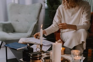 a woman sitting at a table with a candle