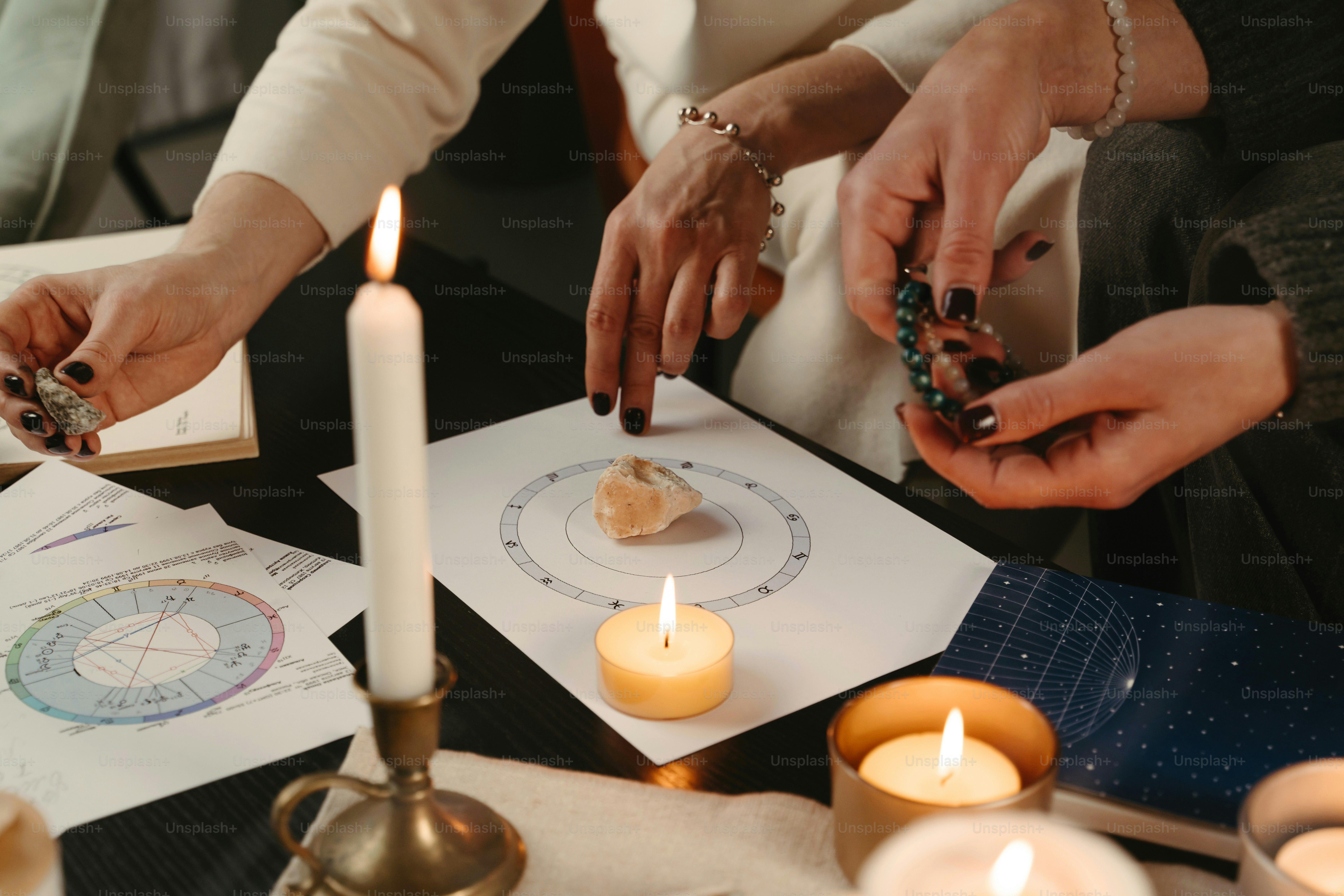 sekelompok orang duduk mengelilingi meja dengan lilin