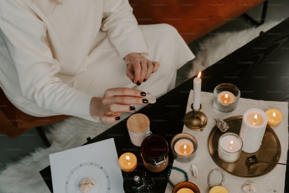 a woman sitting at a table with candles on it
