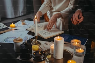a person sitting at a table with candles