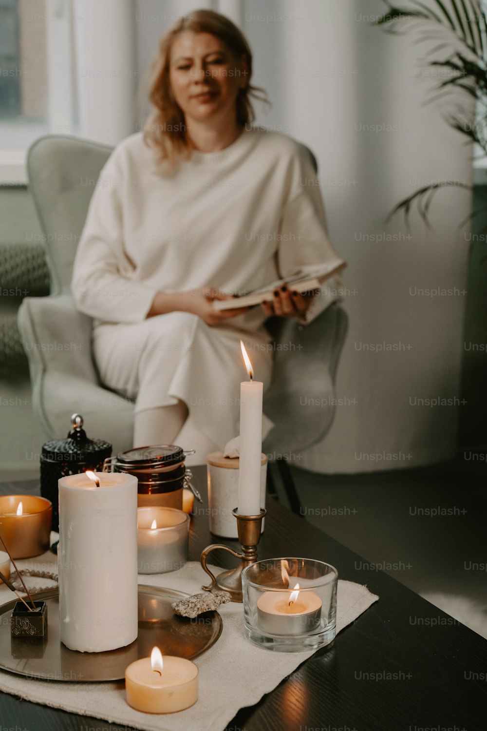 uma mulher sentada em uma mesa com velas sobre ela