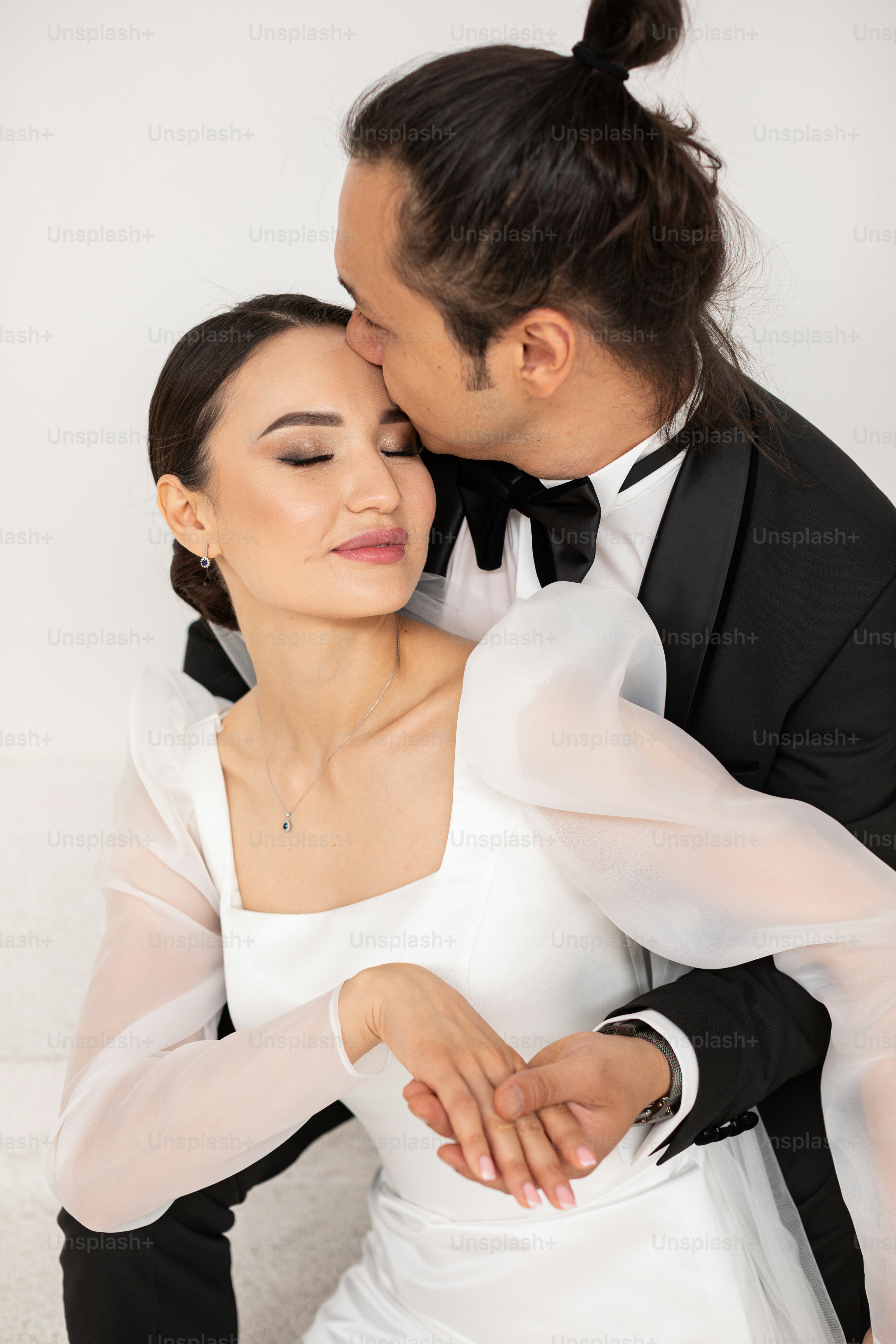 A bride and groom embracing each other under a chandelier photo – Love ...