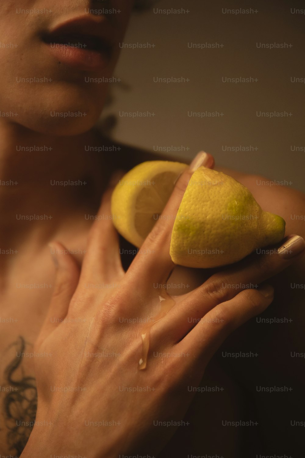 a man holding a lemon and a piece of fruit