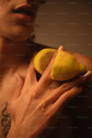 a man holding a lemon and a piece of fruit