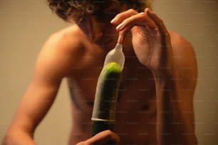 a man holding a bottle with a green substance inside of it