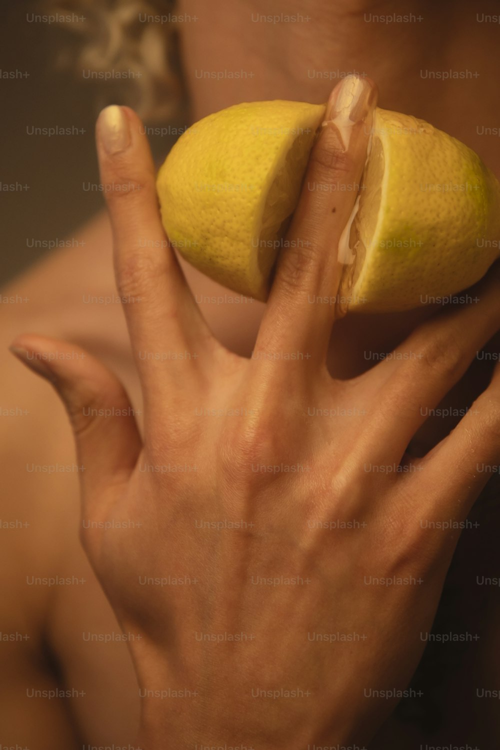 una mujer sosteniendo un limón en su mano derecha