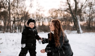a woman and a child playing in the snow