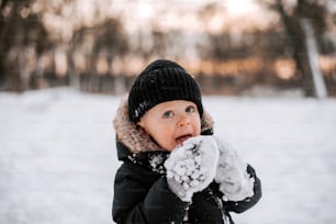 a small child wearing a black jacket and a black hat