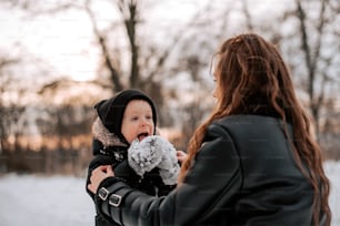 a woman holding a baby in the snow