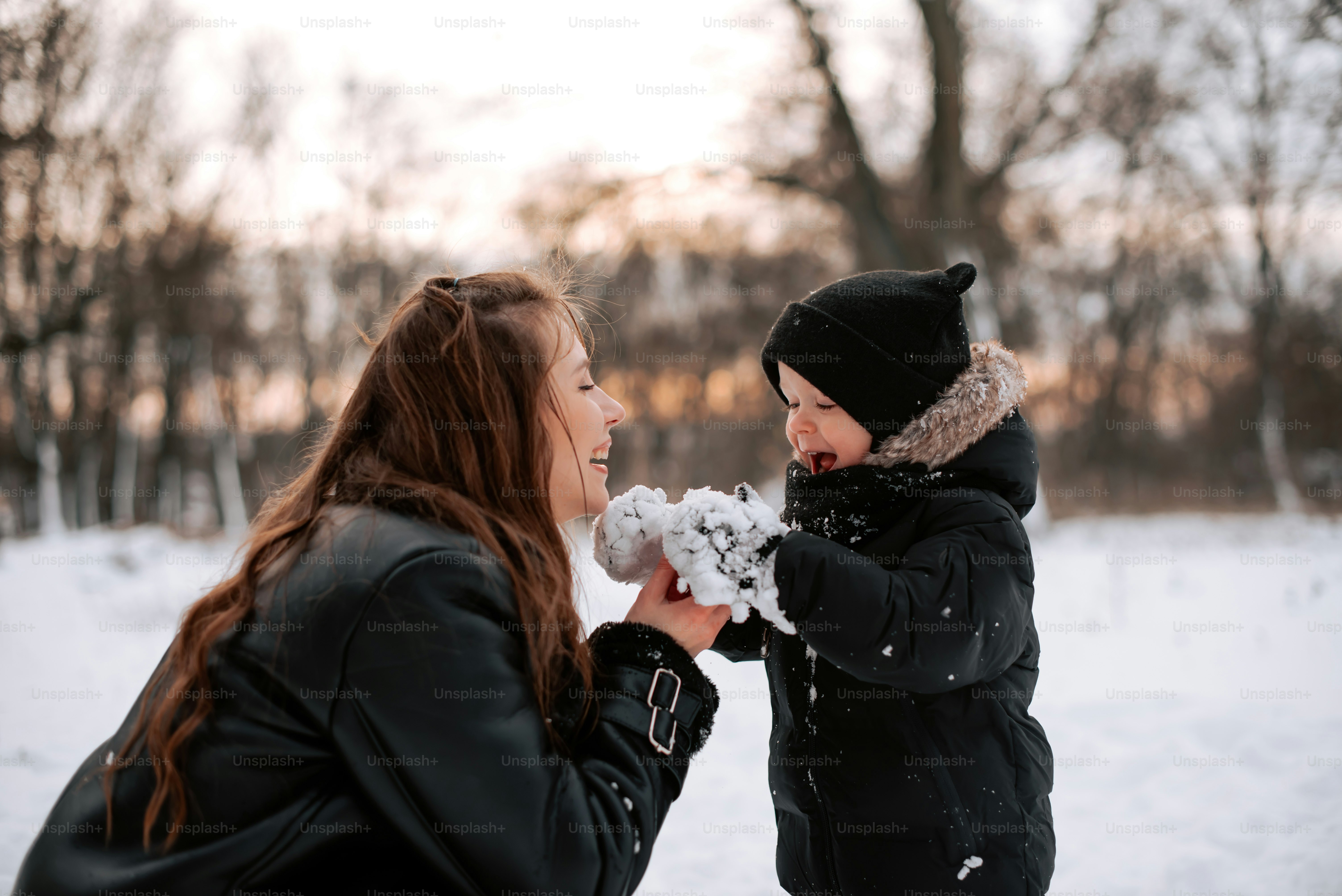 a woman and a child playing in the snow