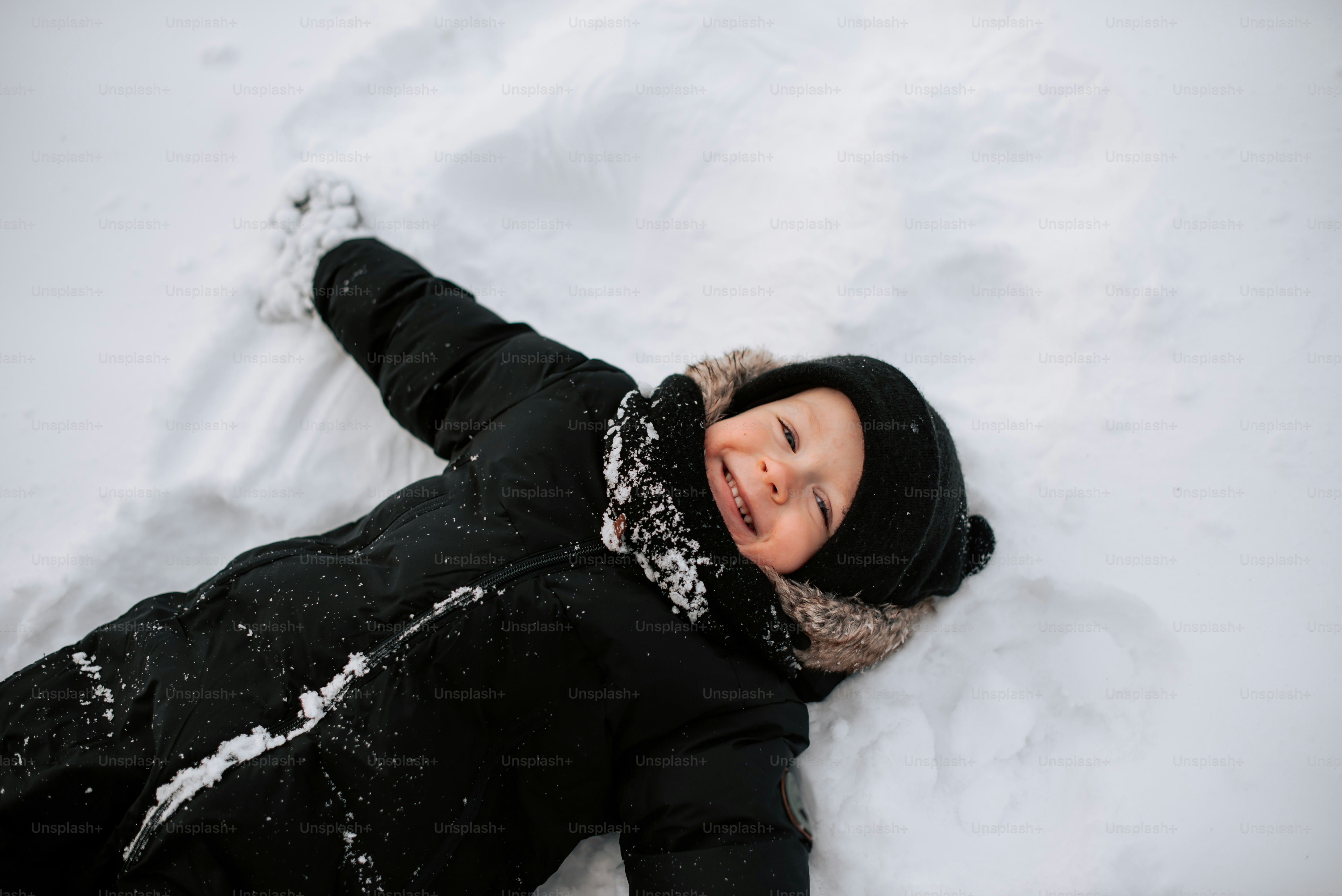 a young child is laying in the snow