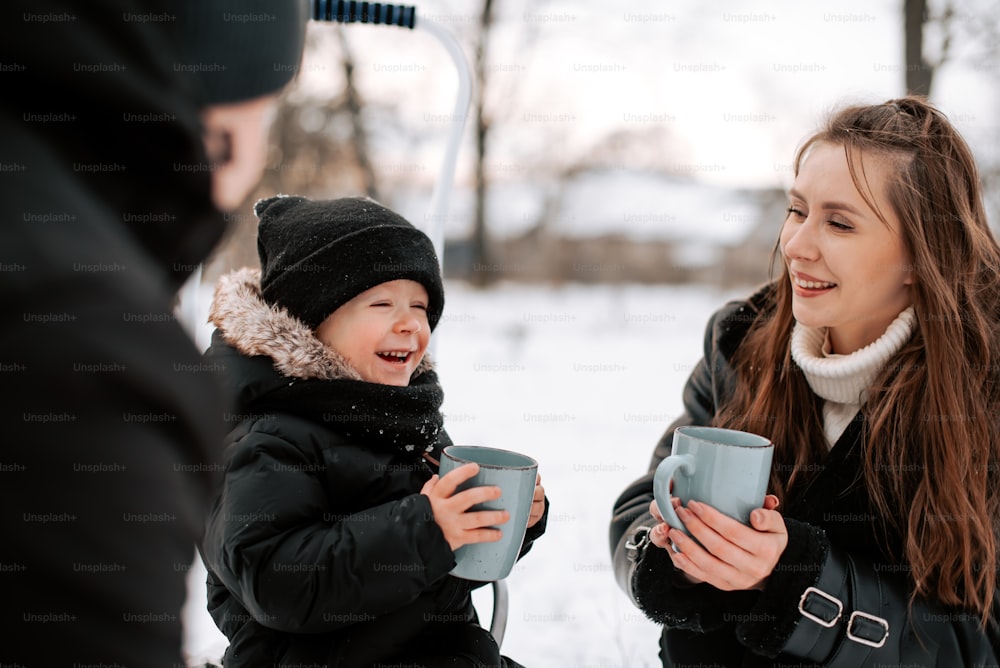 a woman holding a cup of coffee next to a little girl