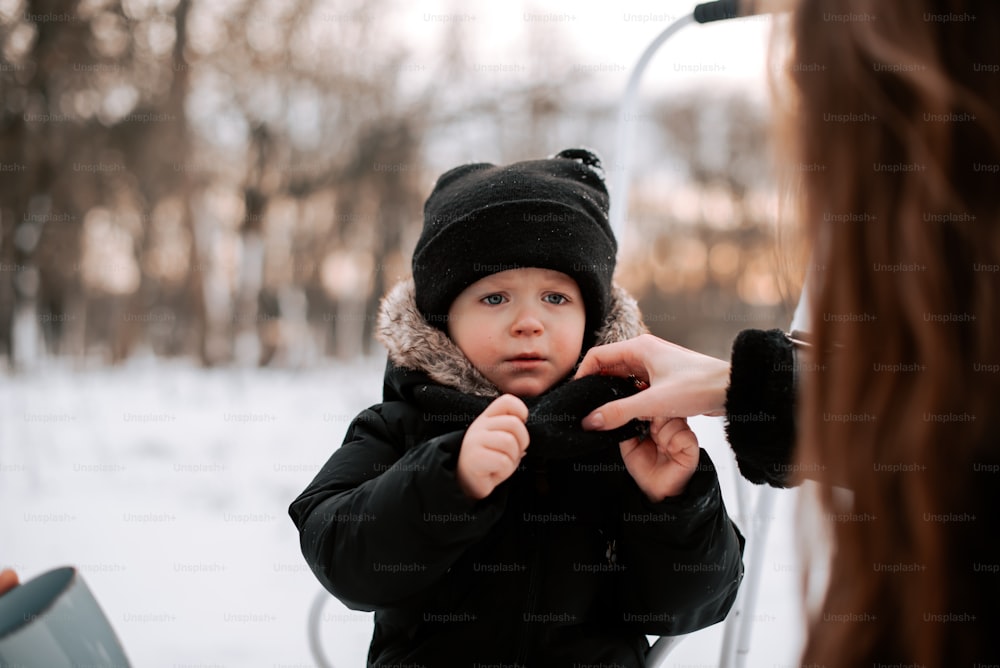 a woman is holding a small child in the snow