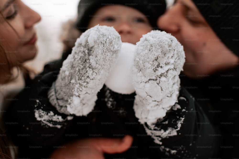 a couple of people that are holding a snowball