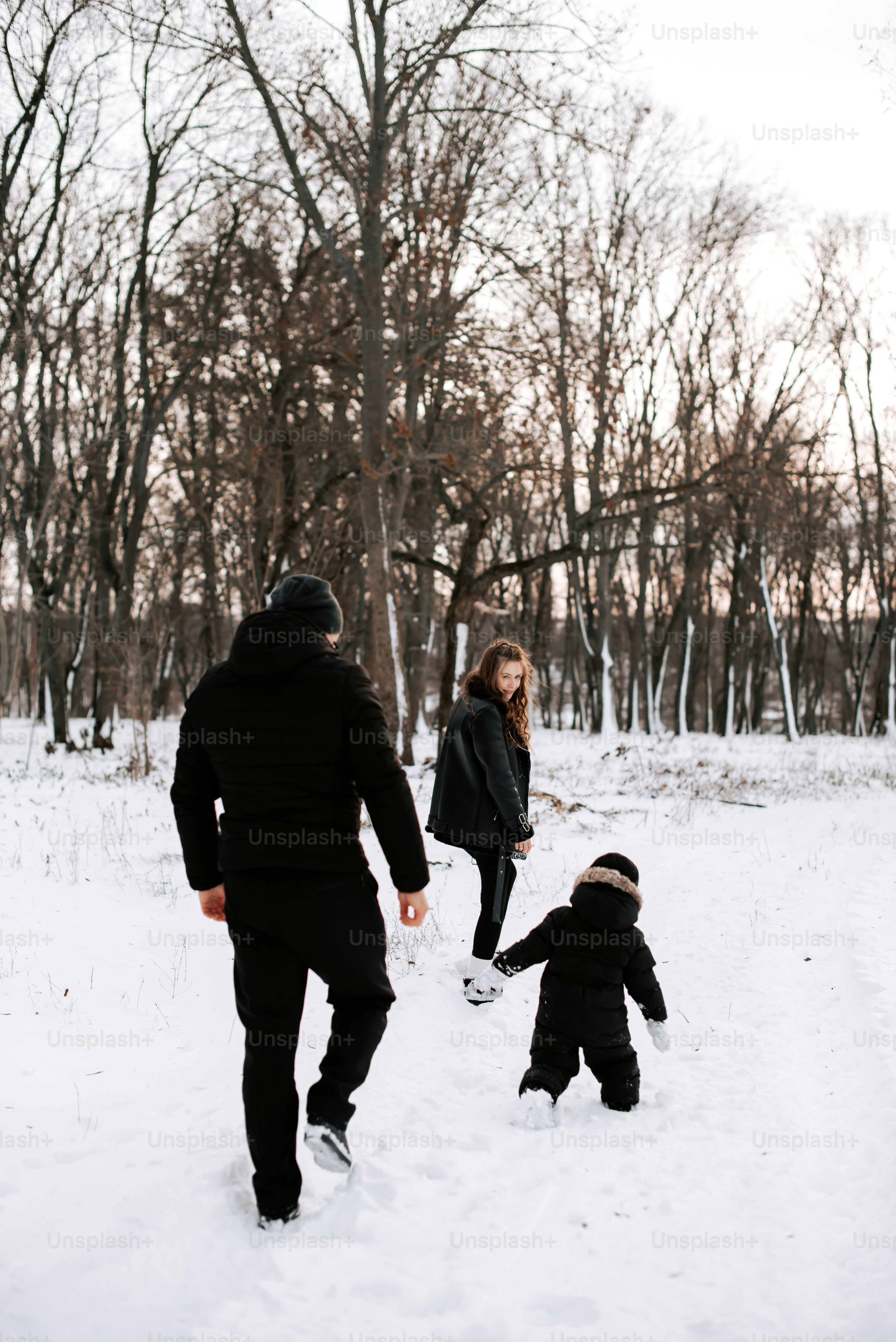 a family playing in the snow in the woods