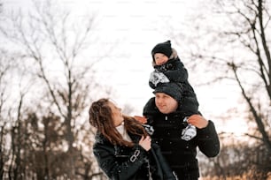 a man holding a child on his shoulders in the snow