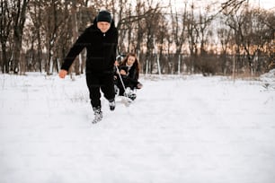 a man and a little girl playing in the snow